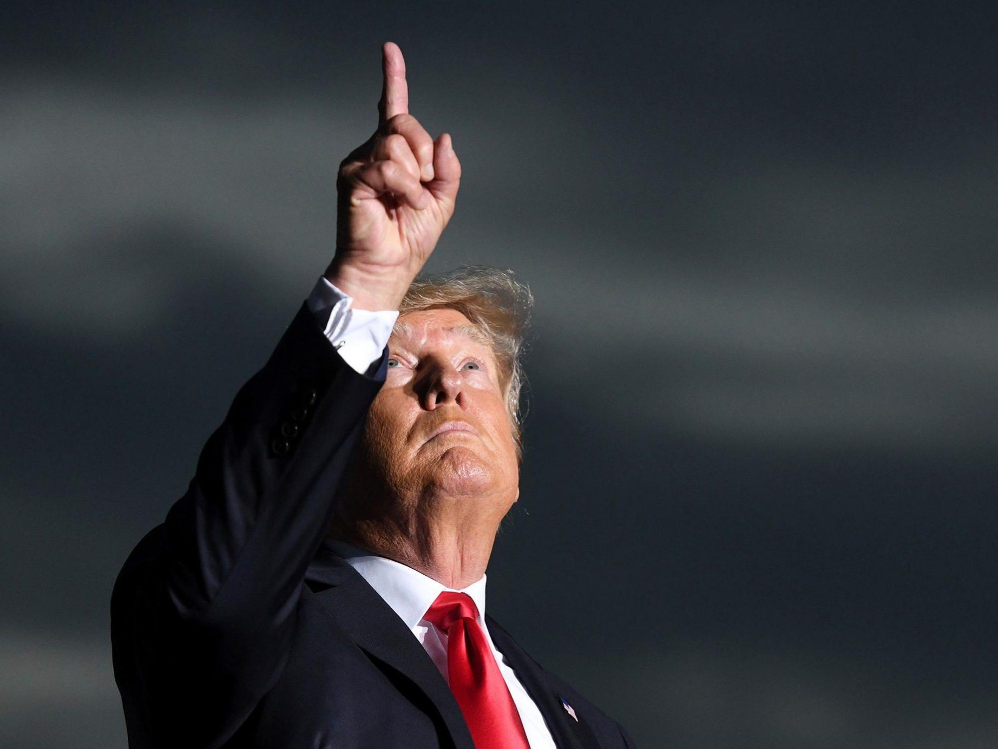 Der ehemalige US-Präsident Donald Trump hält während einer Kundgebung im Juli eine Schweigeminute für die Opfer des Gebäudeeinsturzes in Surfside (Florida), er blickt nach oben, deutet mit dem Fin