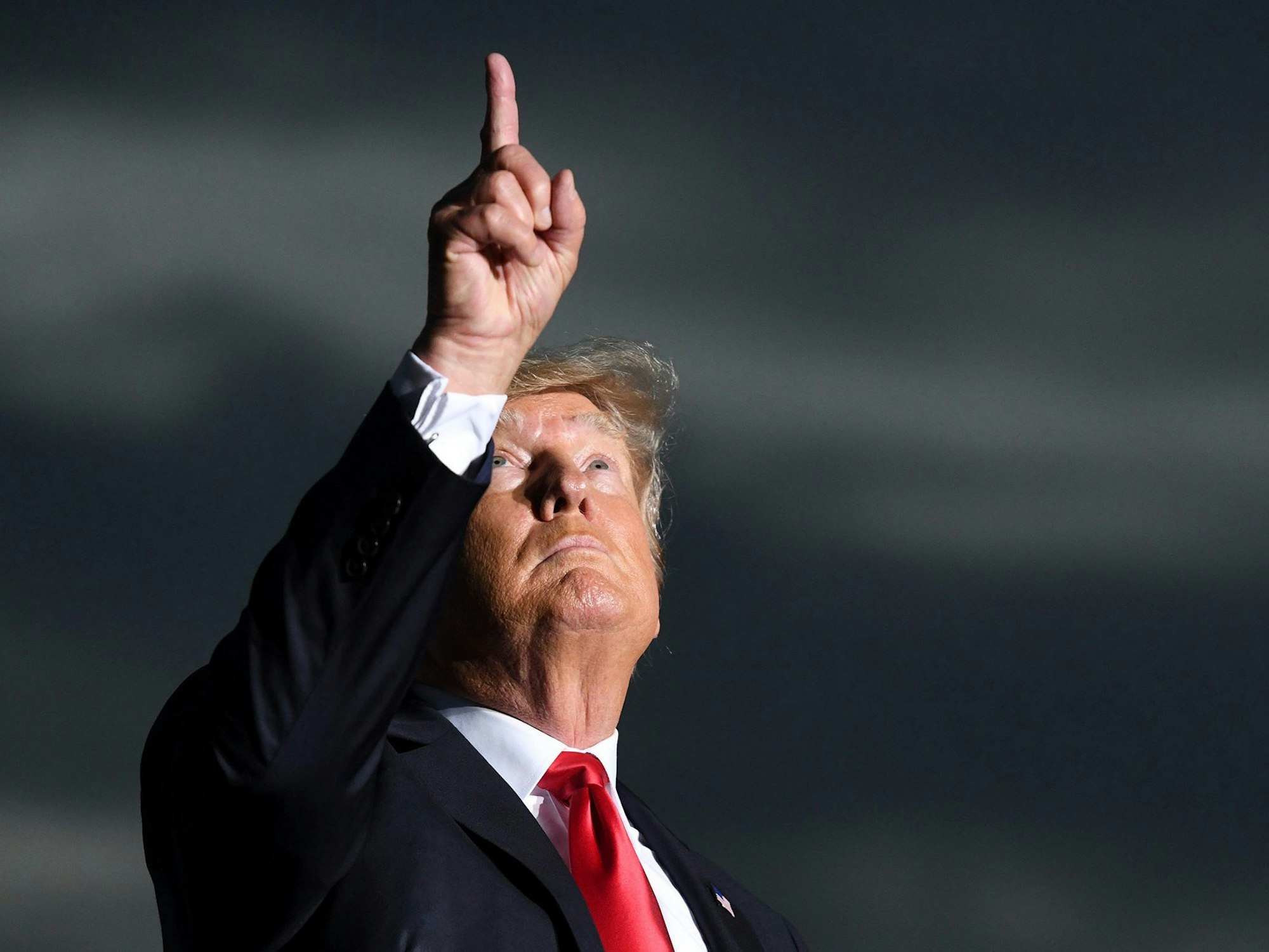 Der ehemalige US-Präsident Donald Trump hält während einer Kundgebung im Juli eine Schweigeminute für die Opfer des Gebäudeeinsturzes in Surfside (Florida), er blickt nach oben, deutet mit dem Fin