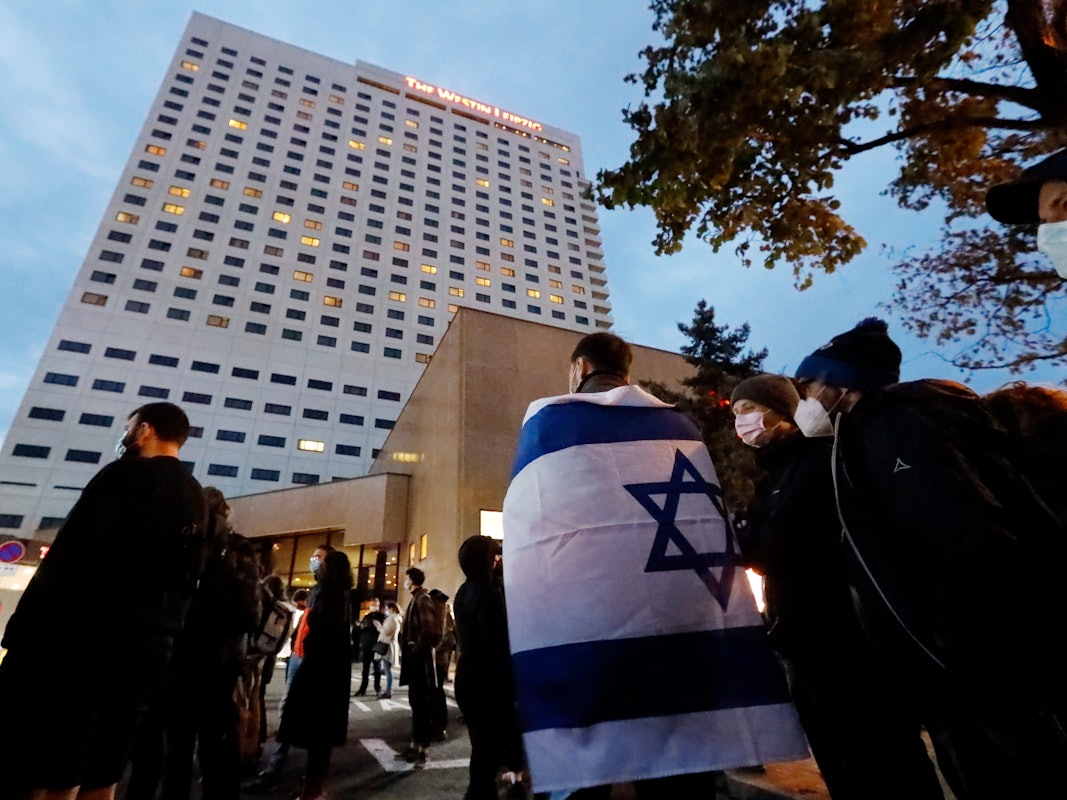 Ein Demonstrant trägt die Fahne Israels über den Schultern. Nach Antisemitismus-Vorwürfen haben sich am Abend Hunderte Menschen vor dem «Westin Hotel» Leipzig versammelt, um Solidarität mit dem Musiker Gil Ofarim und Jüdinnen und Juden in Deutschland zu zeigen.