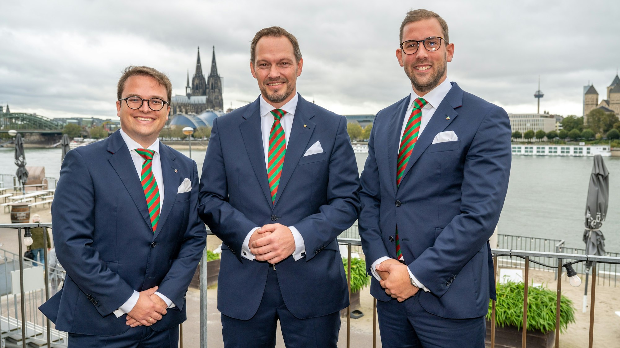 Das designierte Dreigestirn posiert gemeinsam vor Rheinkulisse in Deutz.