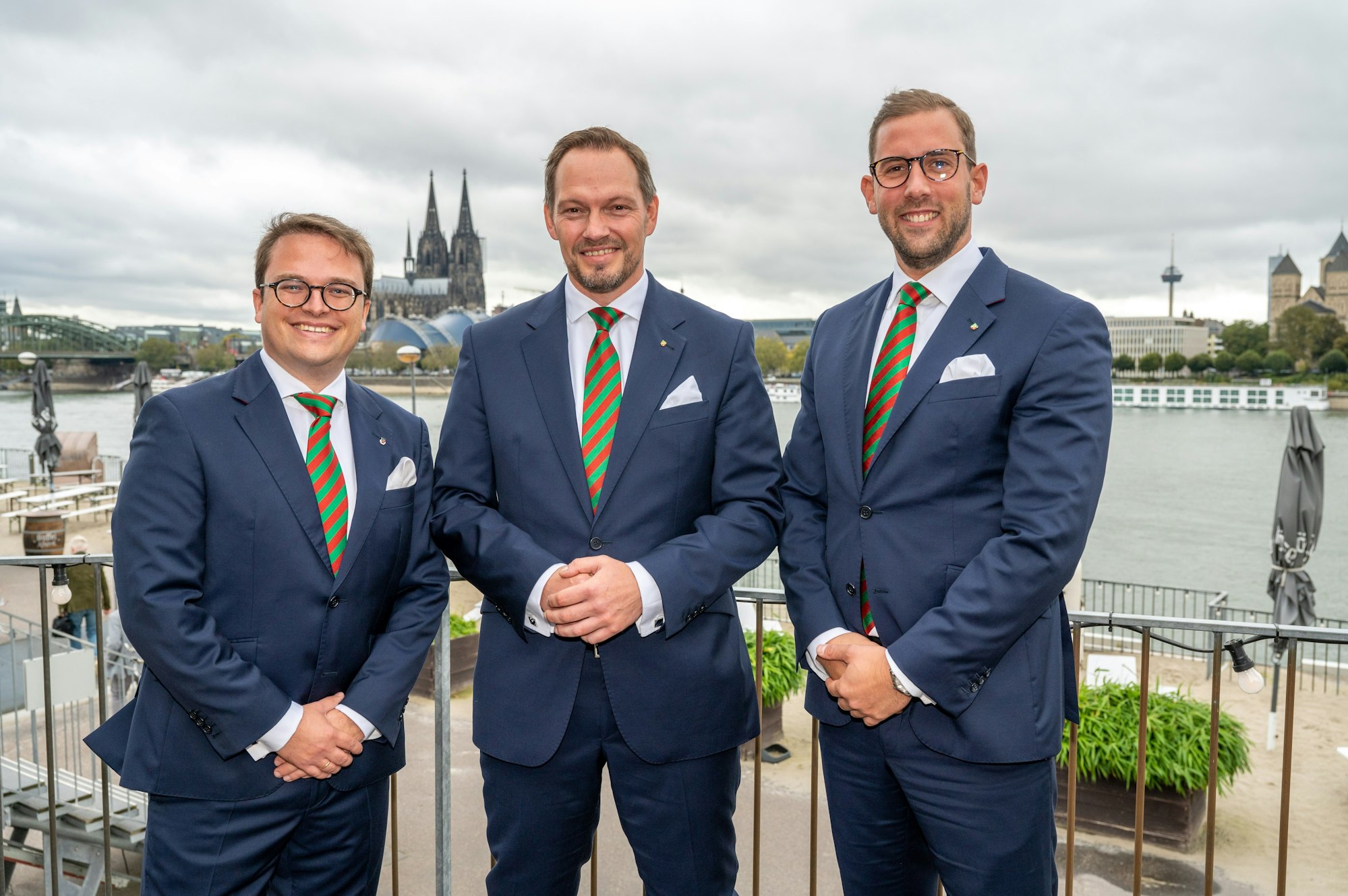 Foto des designierten Dreigestirns im Oktober vor dem Dom-Panorama.