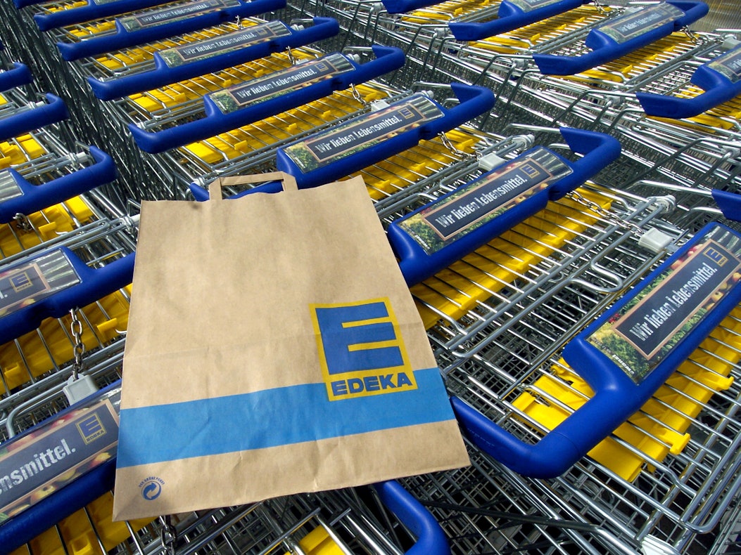 Eine Edeka-Tüte liegt auf einem Einkaufswagen. Die Supermarktkette ruft Sangria zurück. Verkauft wurde das alkoholische Getränk auch in Nordrhein-Westfalen.