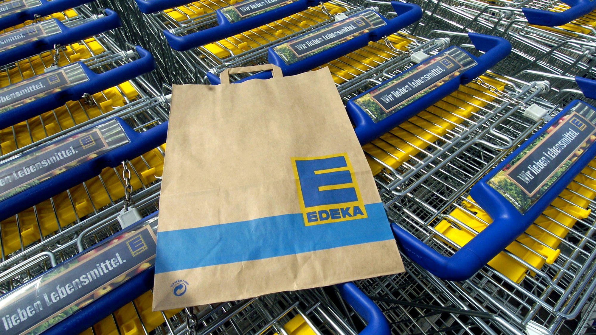 Eine Edeka-Tüte liegt auf einem Einkaufswagen. Die Supermarktkette ruft Sangria zurück. Verkauft wurde das alkoholische Getränk auch in Nordrhein-Westfalen.
