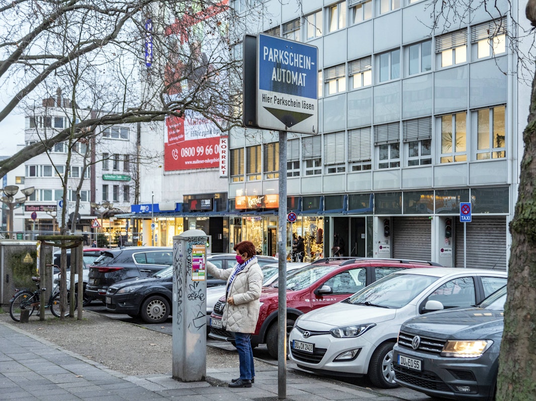 Eine Frau zeiht in Duisburg einen Parkschein.