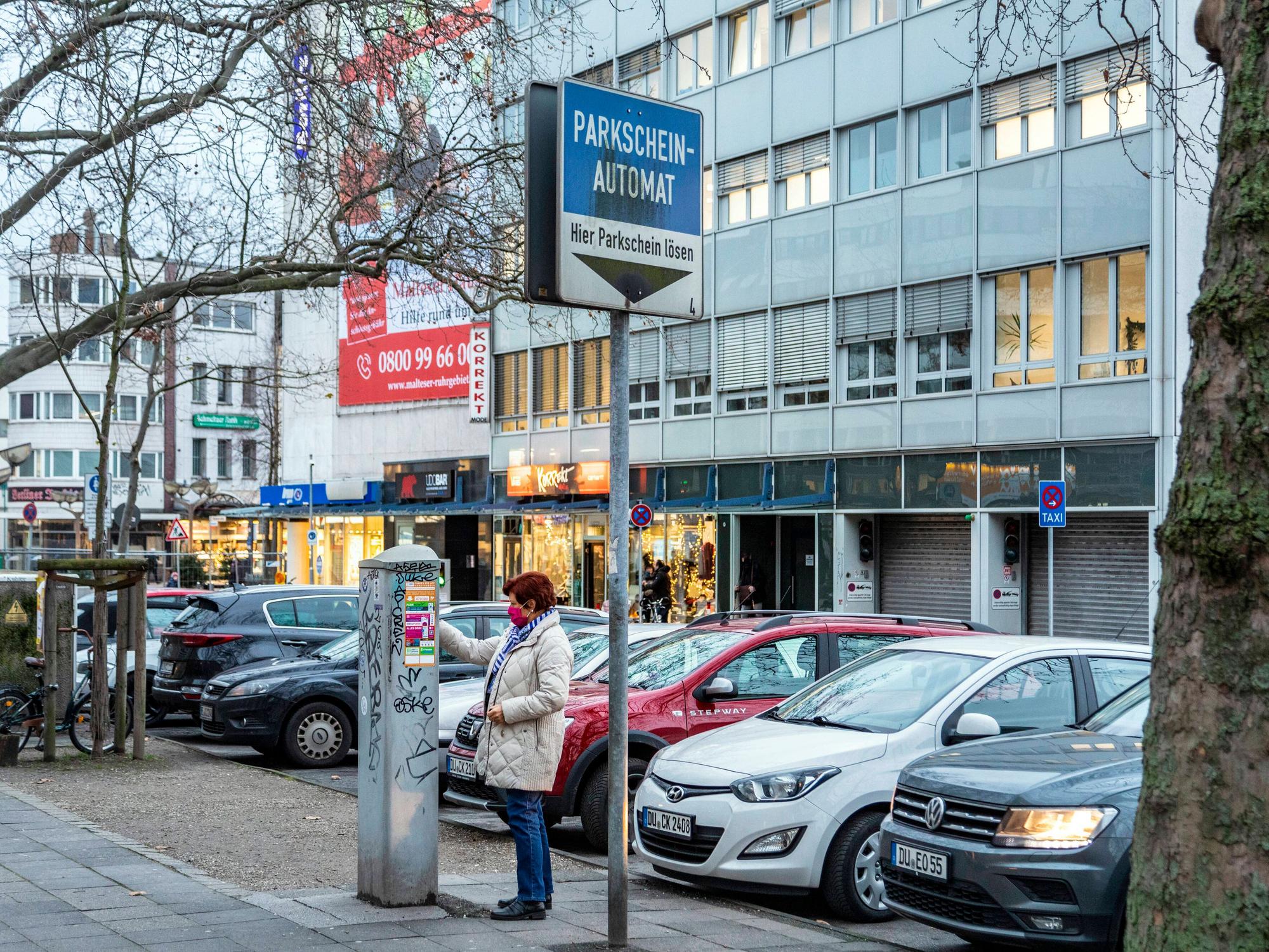 Eine Frau zeiht in Duisburg einen Parkschein.