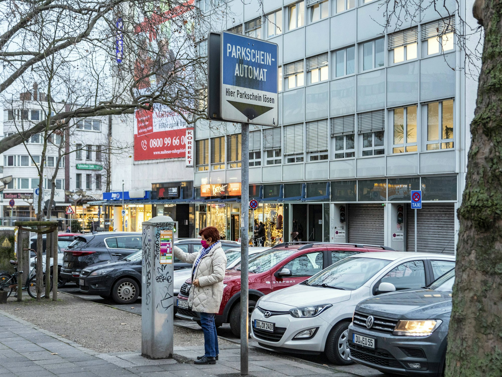 Eine Frau zeiht in Duisburg einen Parkschein.