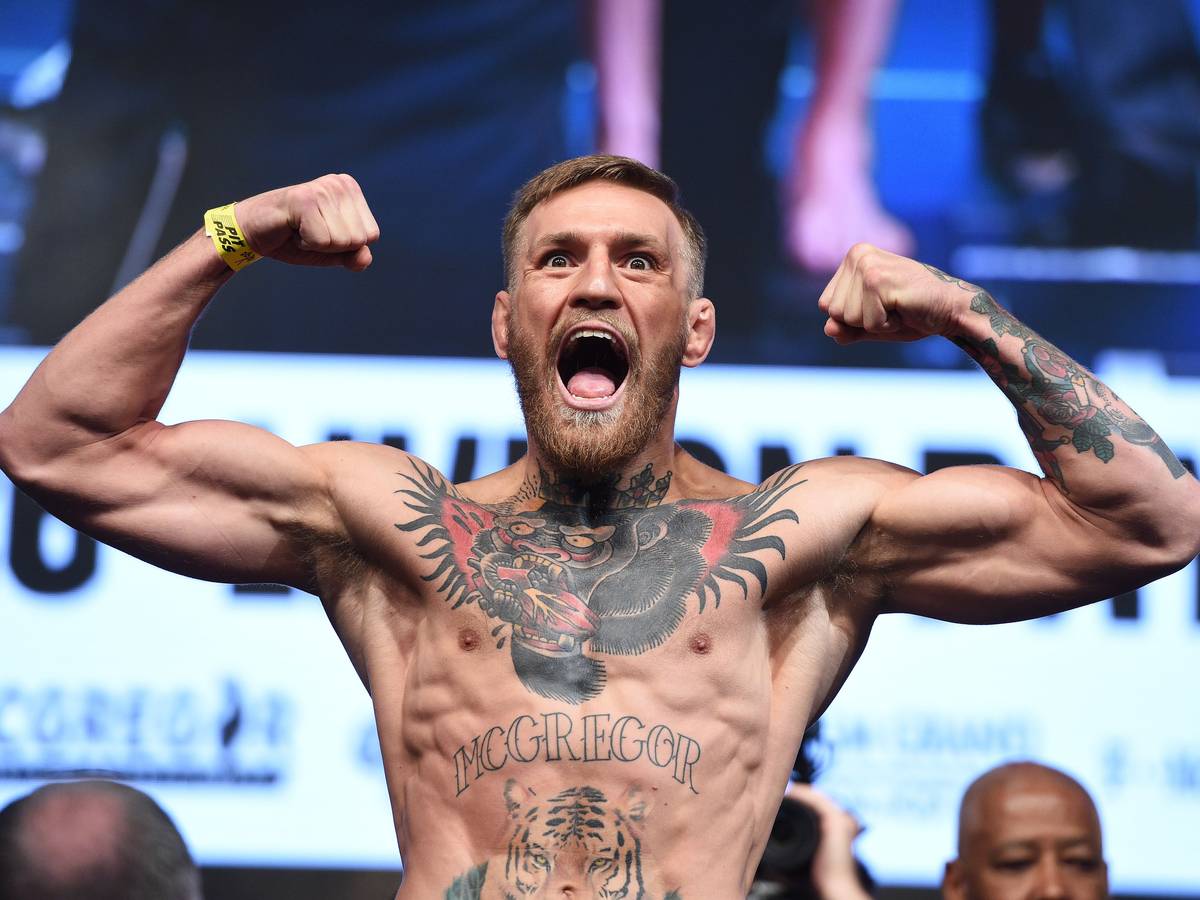 Conor McGregor schreit ins Publikum während er eine Doppel-Bizeps-Pose macht
