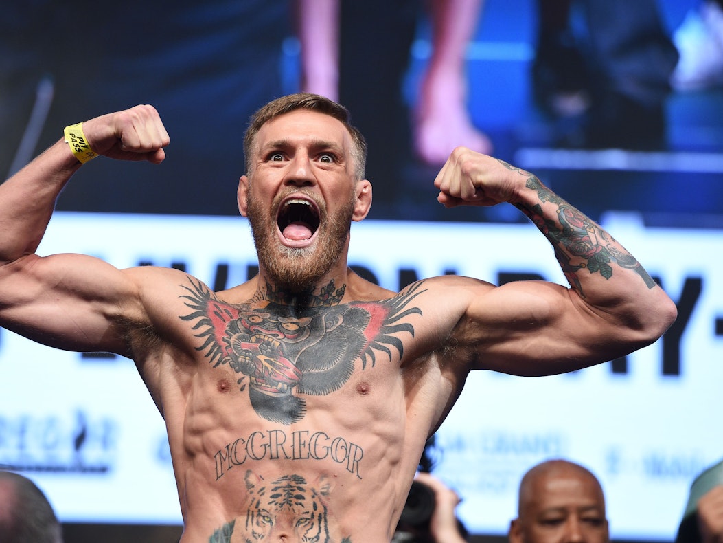 Conor McGregor schreit ins Publikum während er eine Doppel-Bizeps-Pose macht