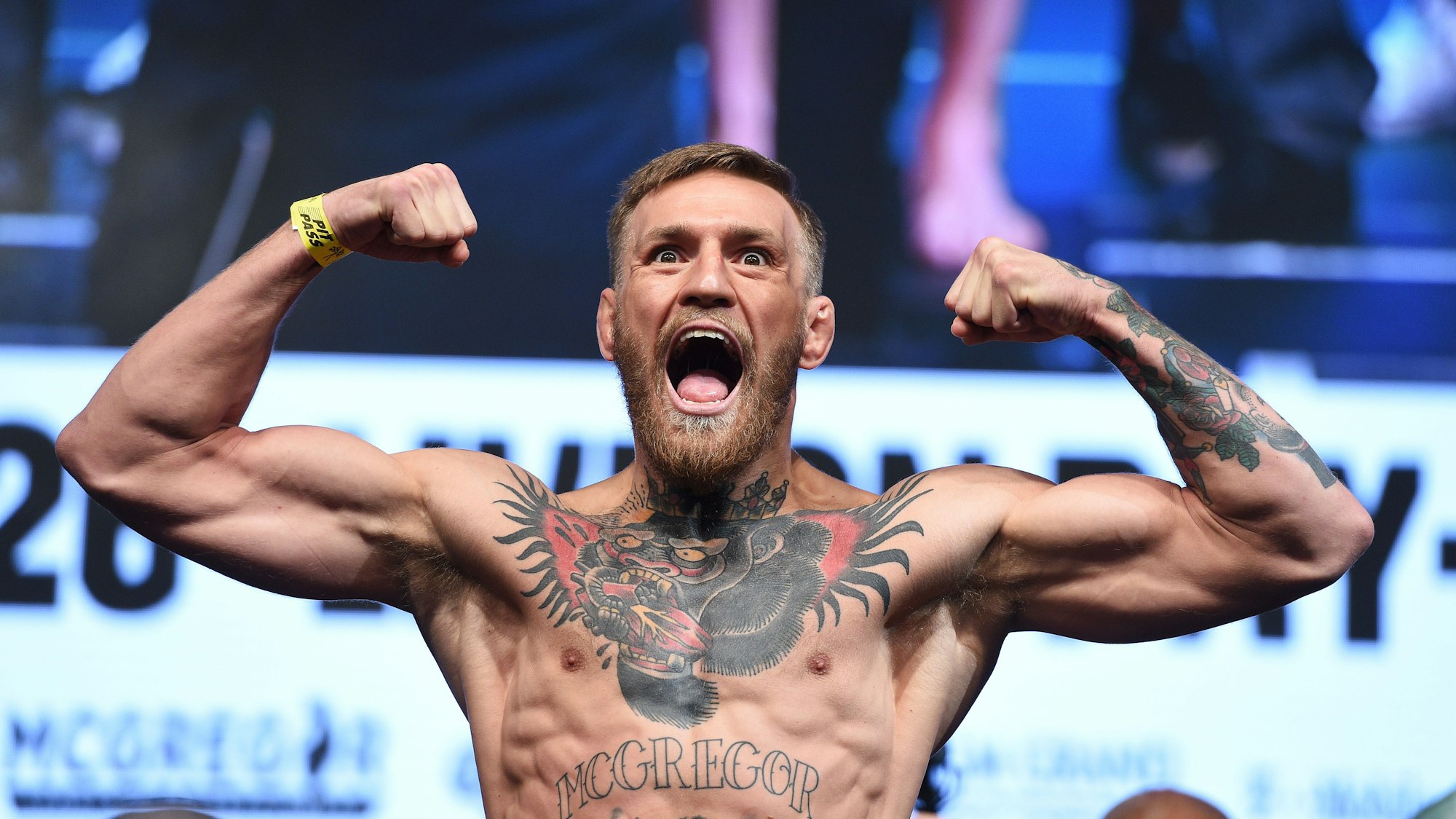 Conor McGregor schreit ins Publikum während er eine Doppel-Bizeps-Pose macht