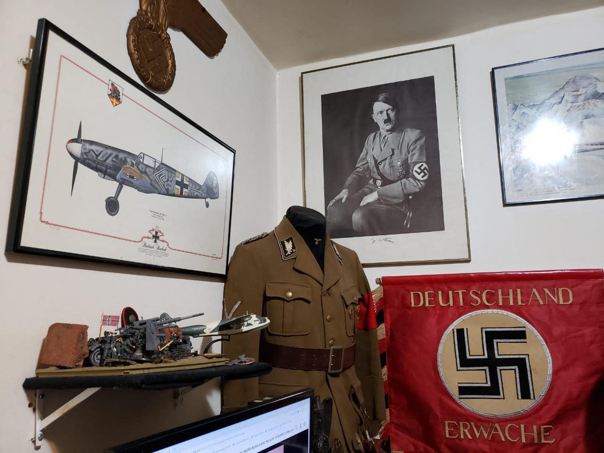 Das Bild zeigt eine Nazi-Uniform und ein Bild mit Adolf Hitler.