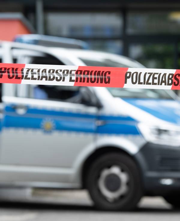 Ein Polizeiauto steht hinter einer Absperrung vor einem Studentenwohnheim im Dresdner Stadtteil Strehlen.