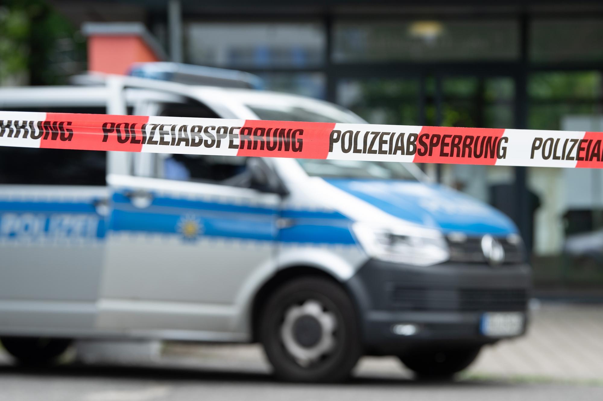 Ein Polizeiauto steht hinter einer Absperrung vor einem Studentenwohnheim im Dresdner Stadtteil Strehlen.