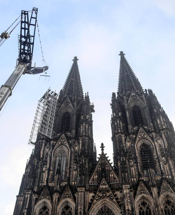 Vor dem Dom und dem Gerüst an der Westfassade steht ein großer Kran