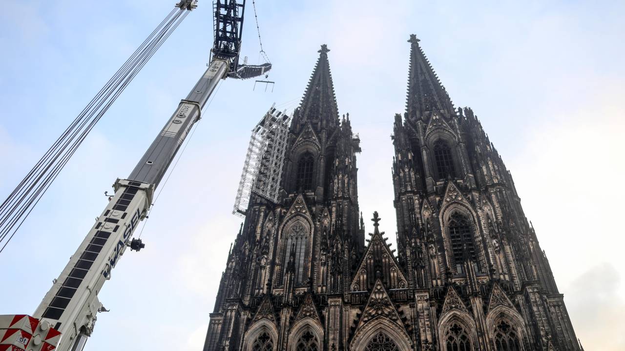 Vor dem Dom und dem Gerüst an der Westfassade steht ein großer Kran