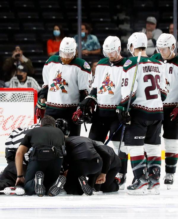 Die Spieler der Arizona Coyotes versammeln sich bei einem NHL-Vorbereitungsspiel um den am Boden liegenden Schiedsrichter Ryan Gibbons, der von Medizinern behandelt wird.