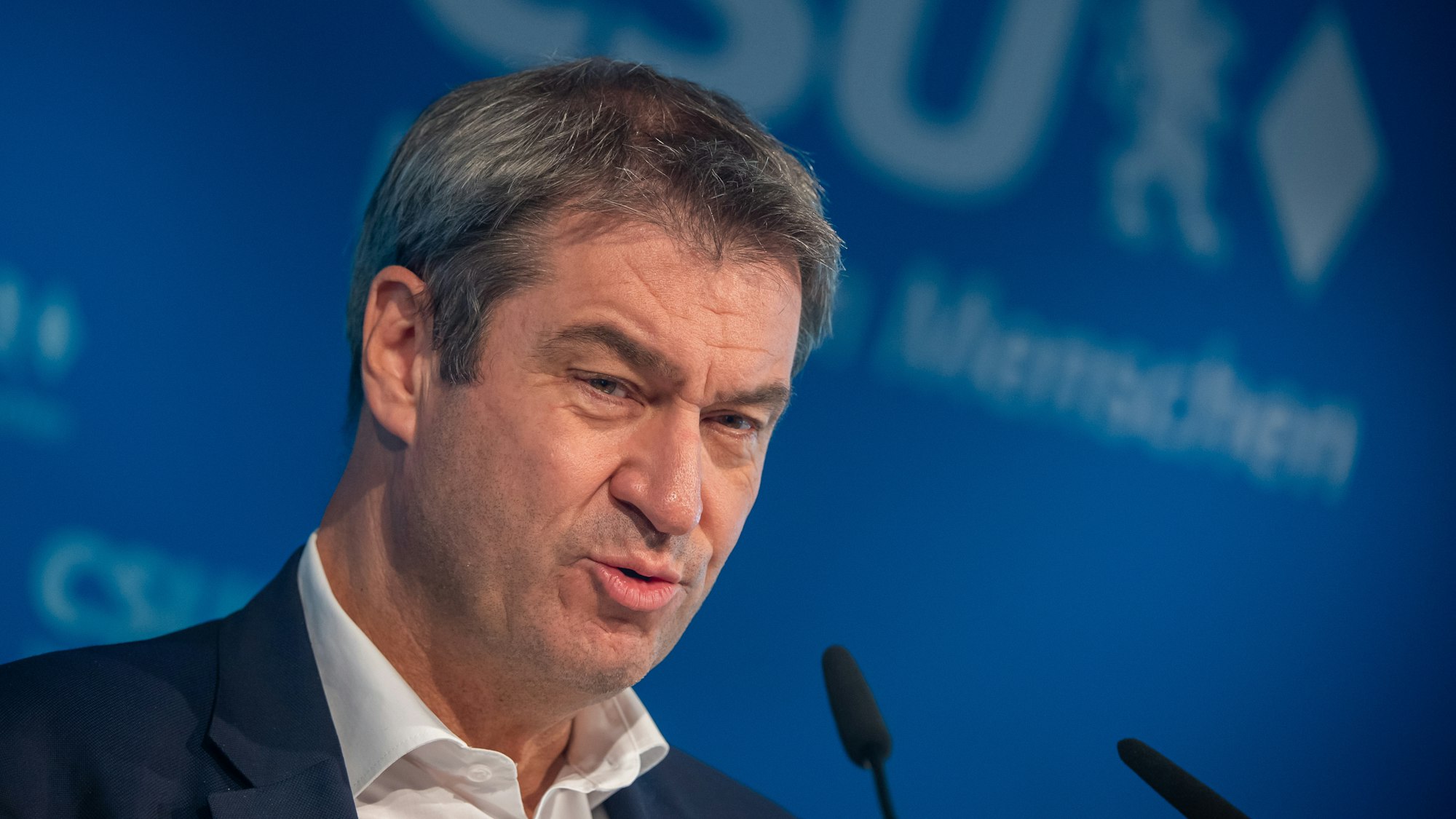 Markus Söder bei einer Pressekonferenz in München vor einer blauen CSU-Leinwand.