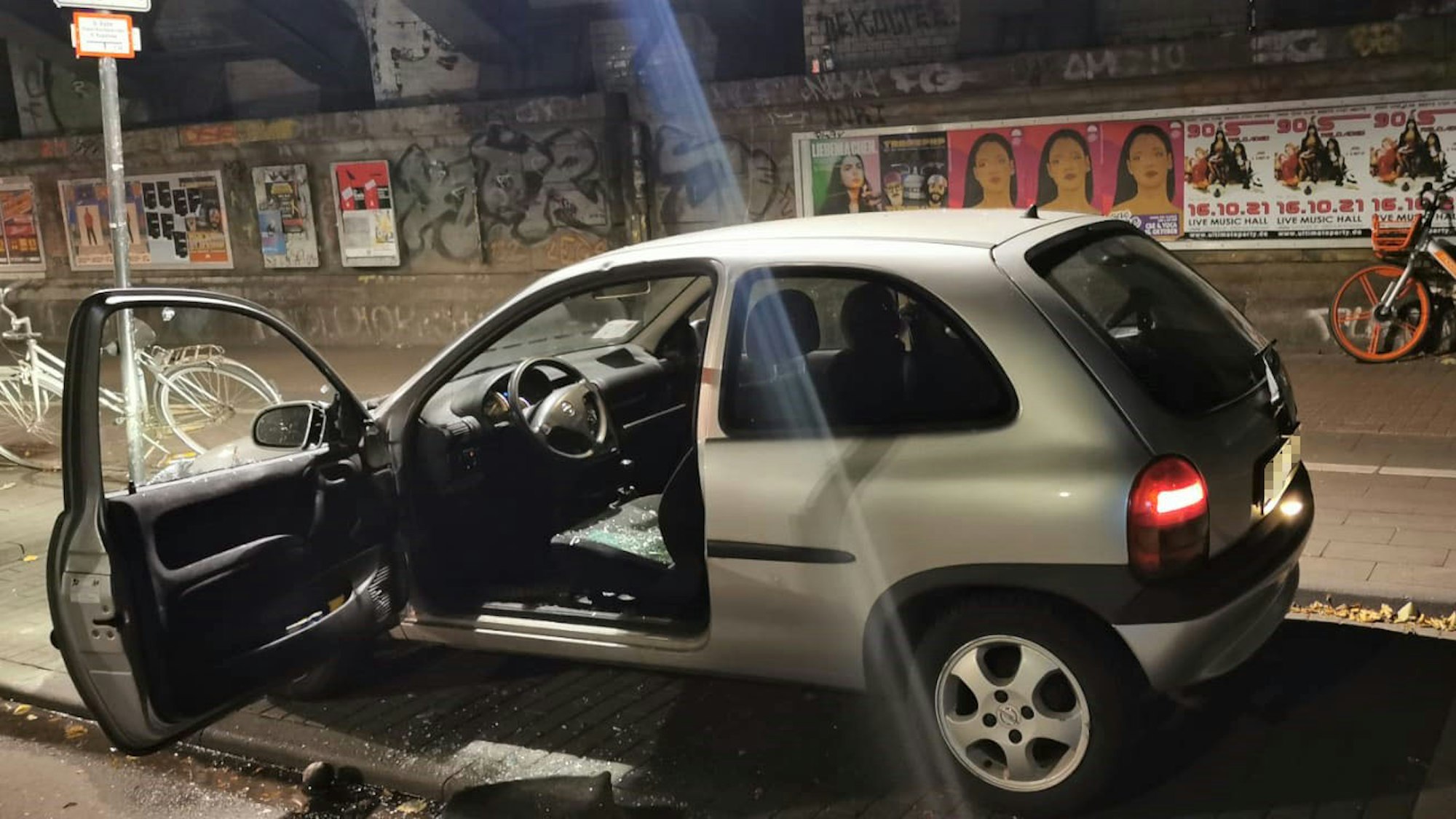 Der Corsa steht mit offener Fahrertür unter der Unterführung.