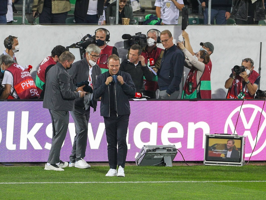 Jens Grittner und Uli Voigt begleiten Hansi Flick zum Interview.