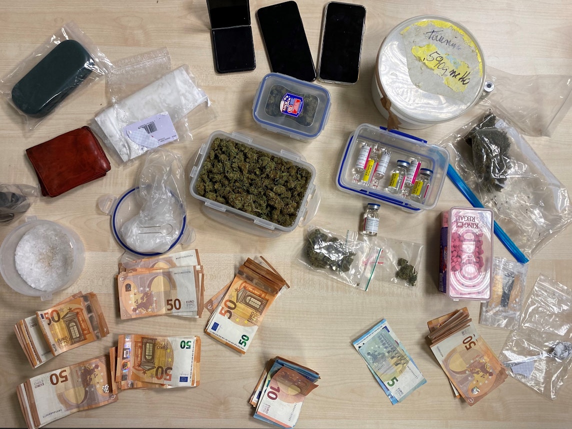Drogen und Bargeld auf einem Tisch ausgebreitet.