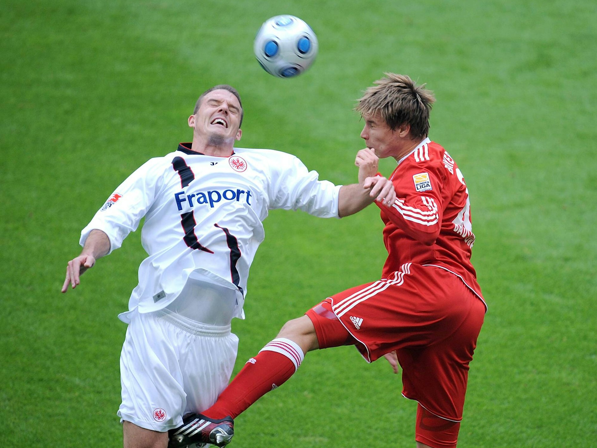 Badstuber köpft den Ball, Alex Meier versucht vergebens, an den Ball zu kommen.
