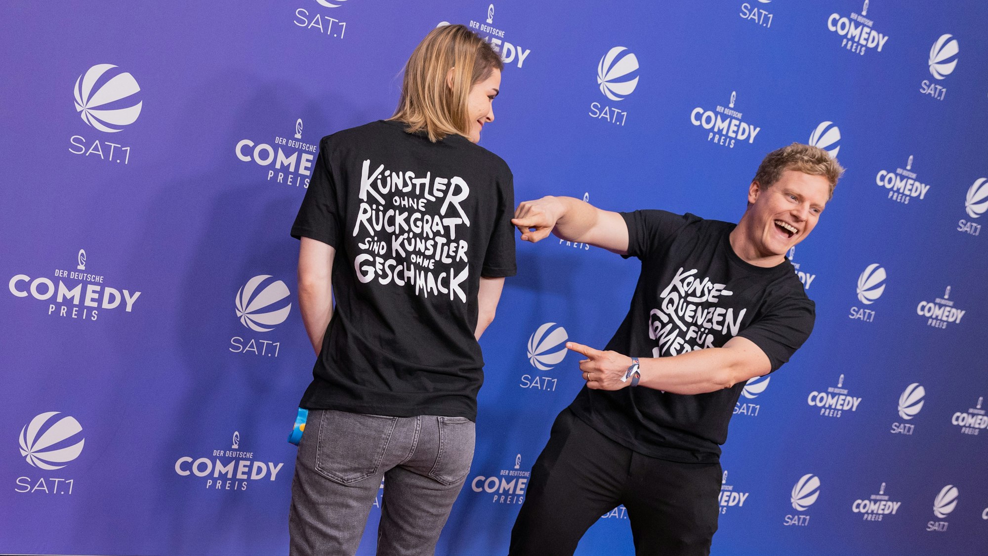 Wegen Luke Mockridge: Hazel Brugger und ihr Mann Thomas Spitzer mit T-Shirt mit der Aufschrift „Konsequenzen für Comedian XY“ kommen über den Roten Teppich zur Verleihung des Deutschen Comedypreises 2021.