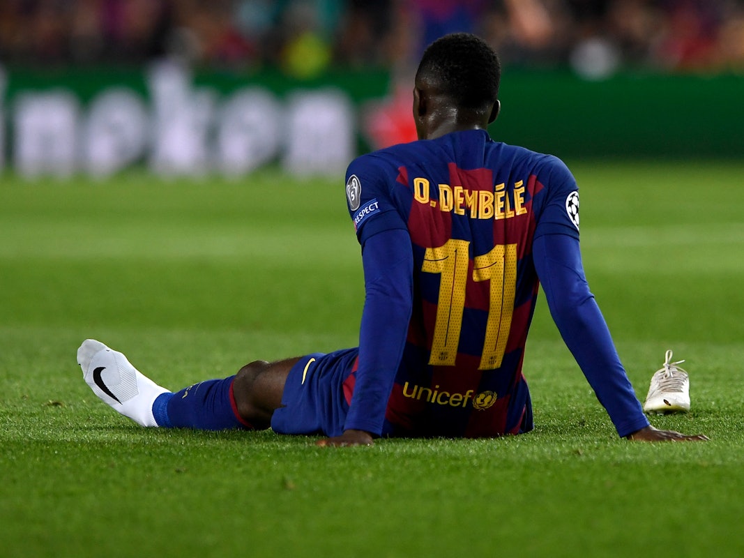 Ousmane Dembélé sitzt bei einem Spiel des FC Barcelona nach einer Verletzung auf dem Rasen des Camp Nou.