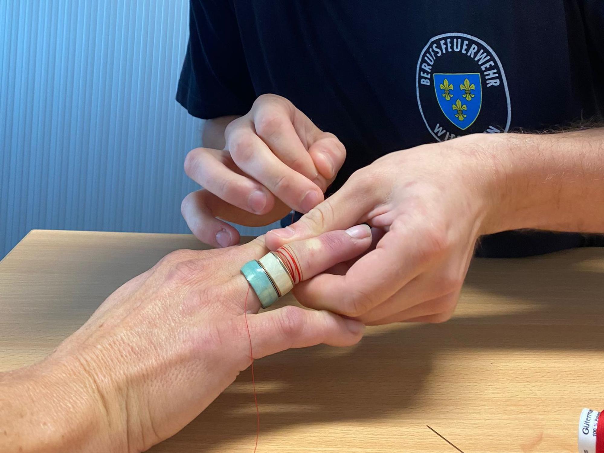 Hier befreit die Wiesbadener Feuerwehr die Frau von dem zu engen Ring. Dabei kommen Nadel und Faden zum Einsatz.