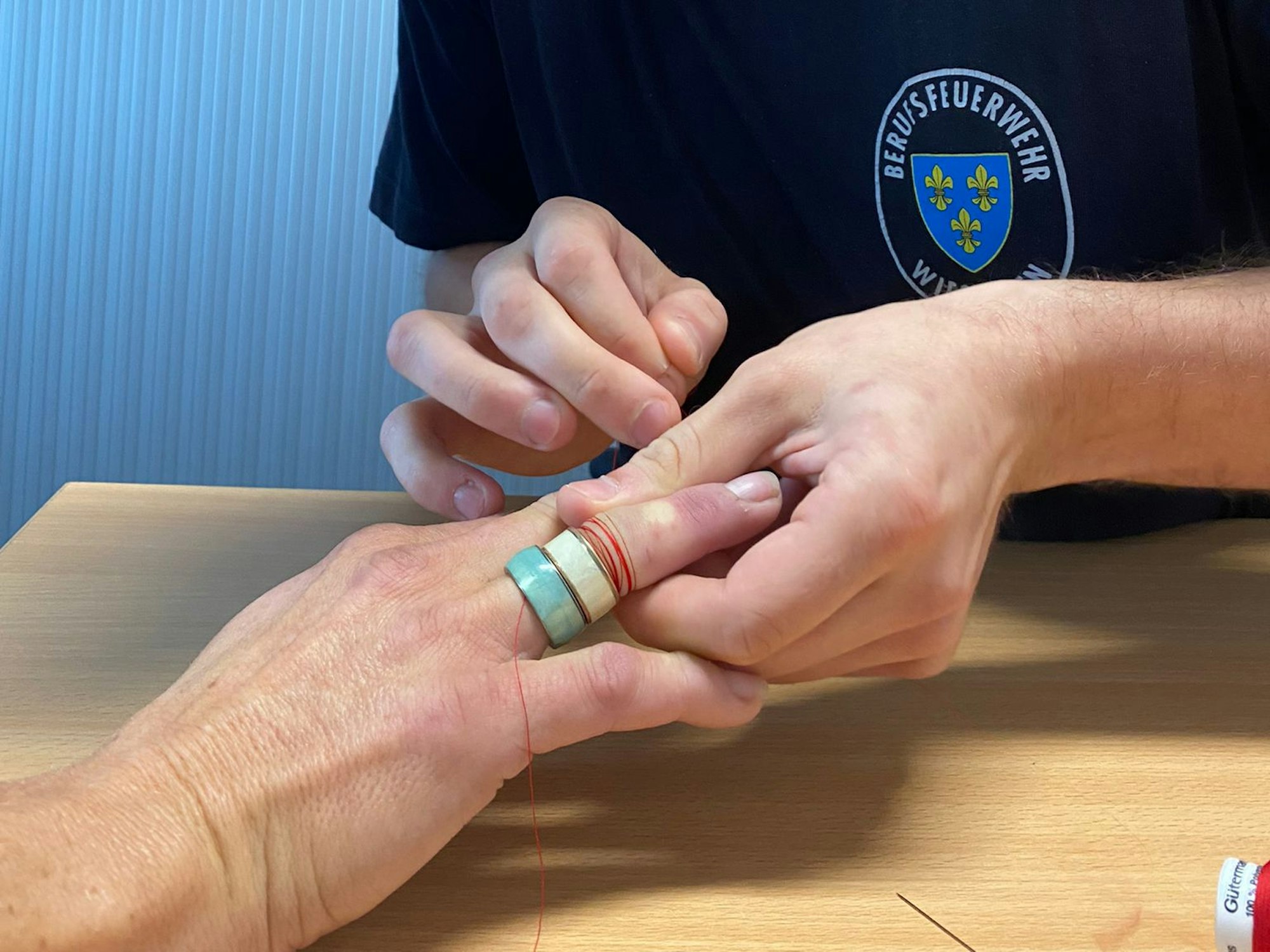 Hier befreit die Wiesbadener Feuerwehr die Frau von dem zu engen Ring. Dabei kommen Nadel und Faden zum Einsatz.