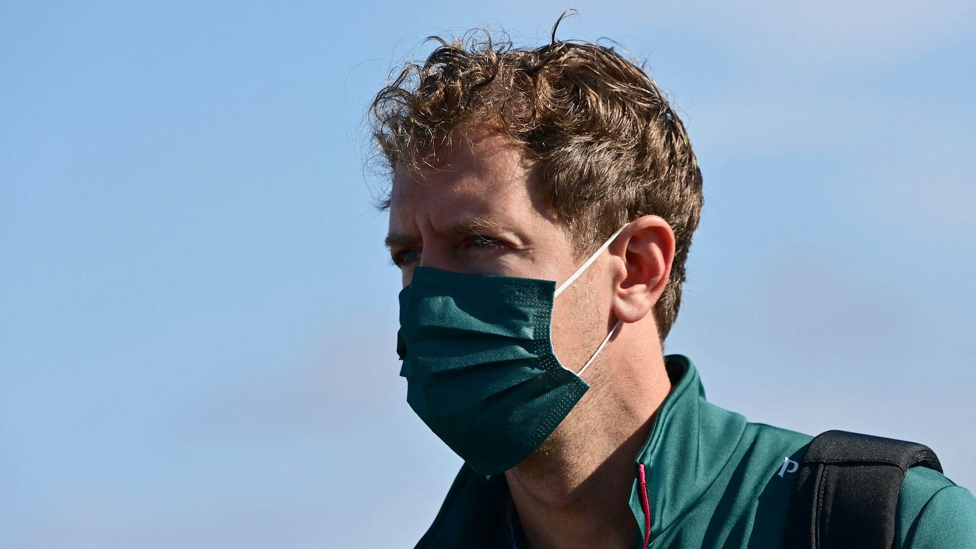 Sebastian Vettel geht mit Mundschutz durch die Boxengasse der Formel 1 in der Türkei.