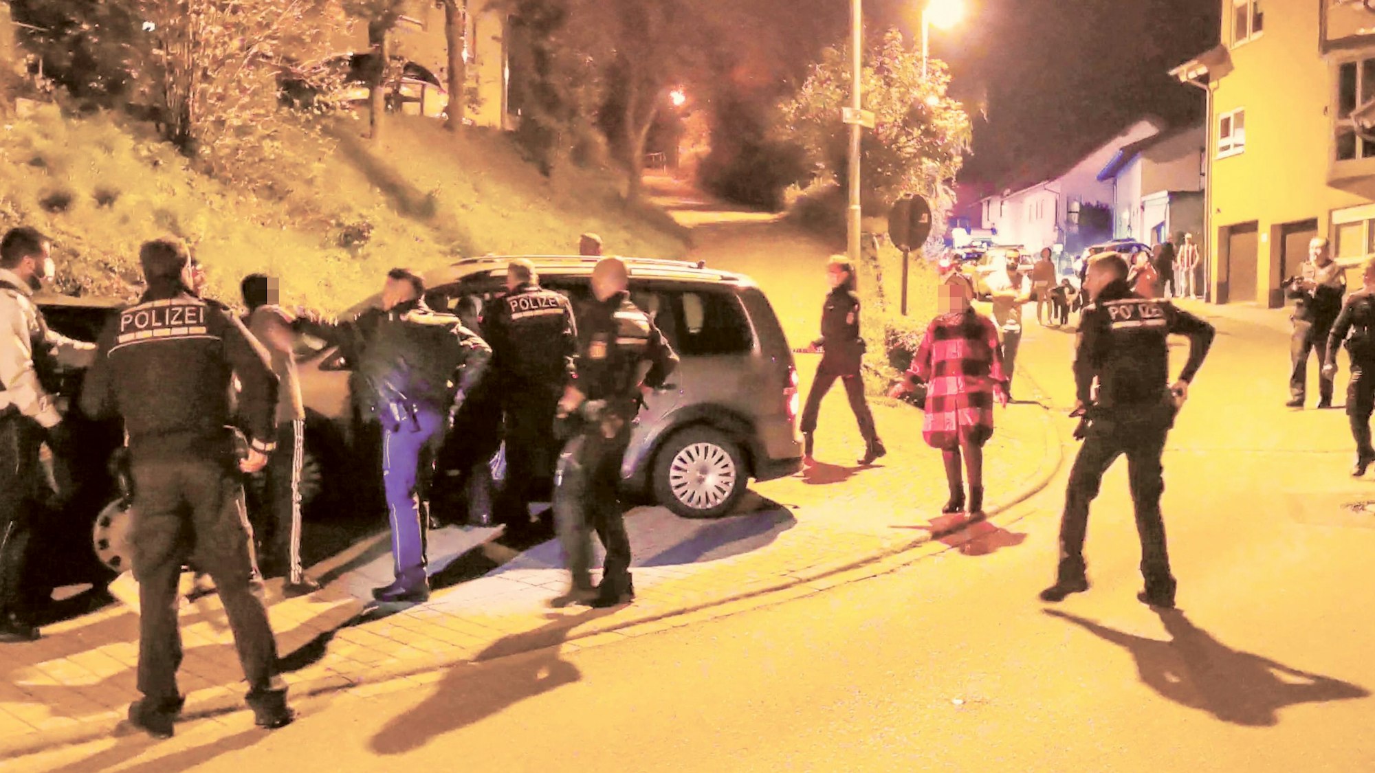 Polizisten versuchen eine Schlägerei zwischen zwei größeren Gruppen zu beruhigen.