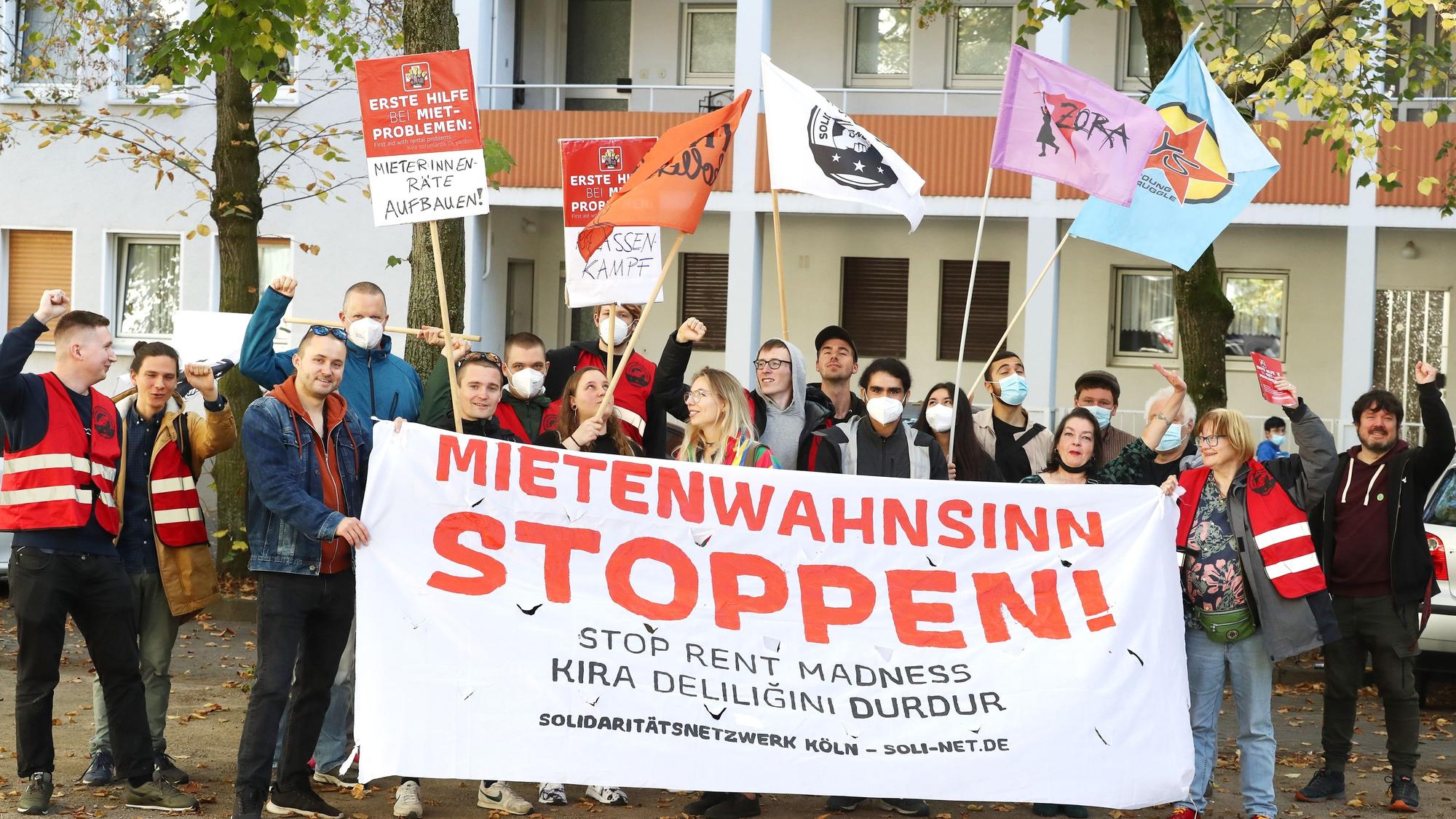 Demonstranten schwenken Fahnen und halten ein Banner