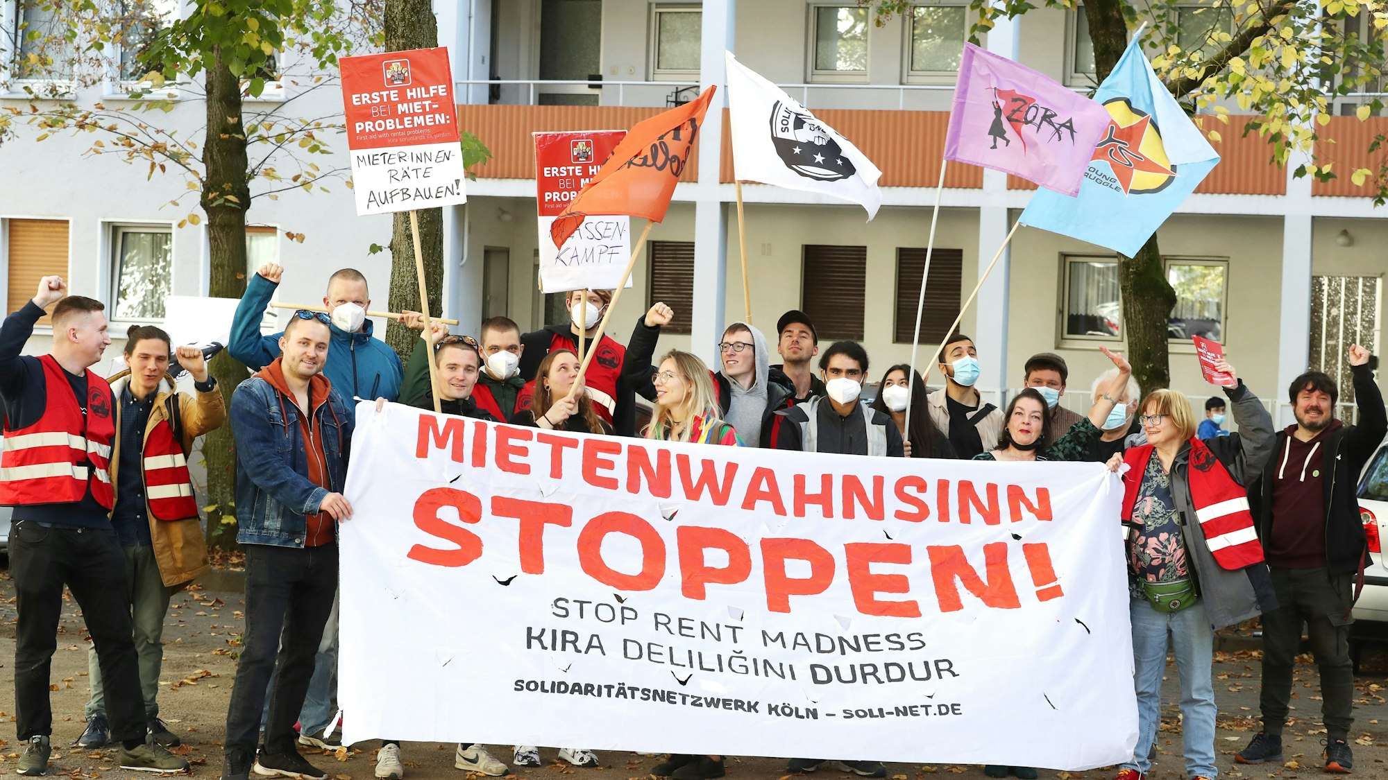 Demonstranten schwenken Fahnen und halten ein Banner