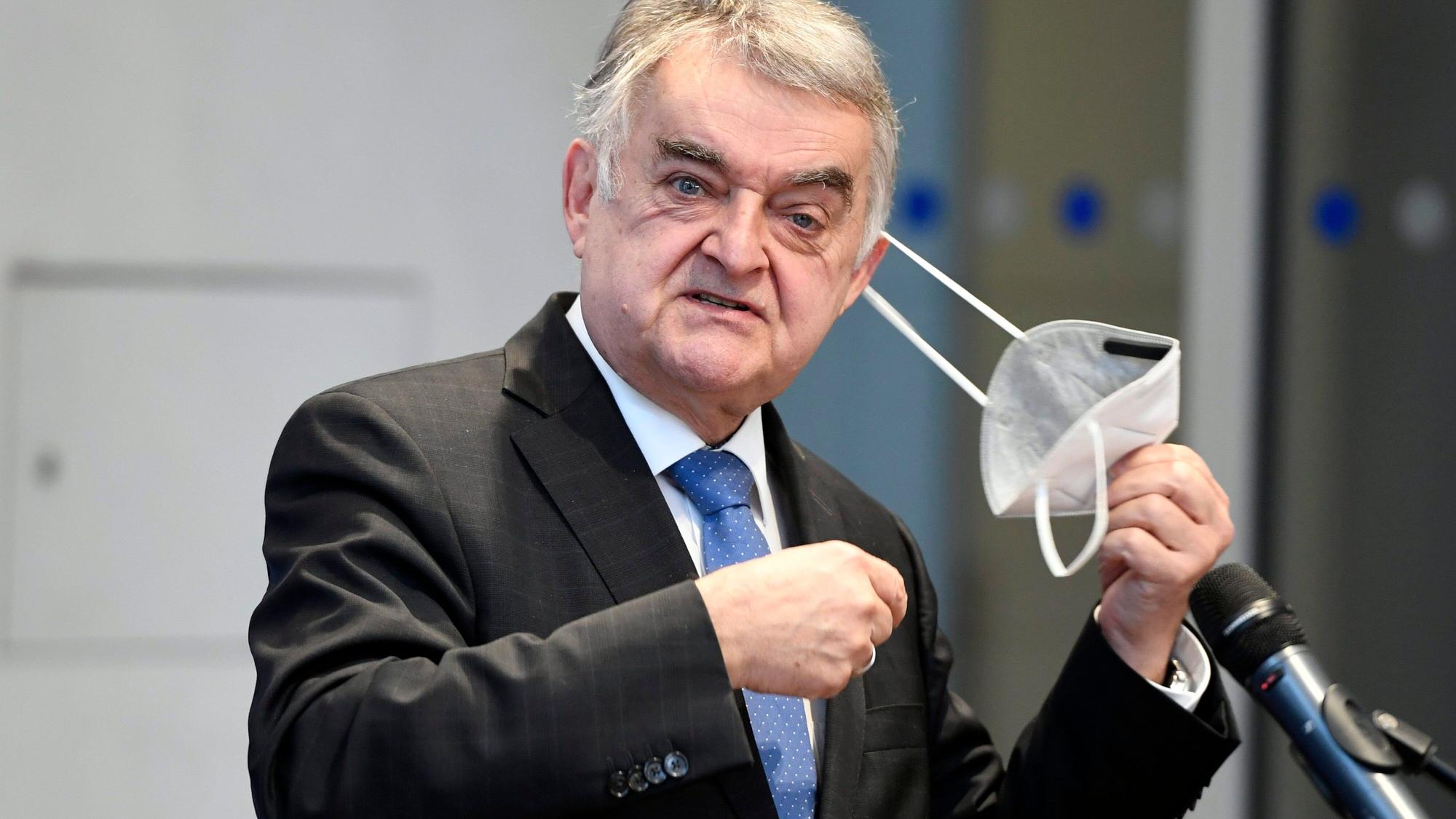 Herbert Reul (CDU), Innenminister von Nordrhein-Westfalen, nimmt seine Maske ab.