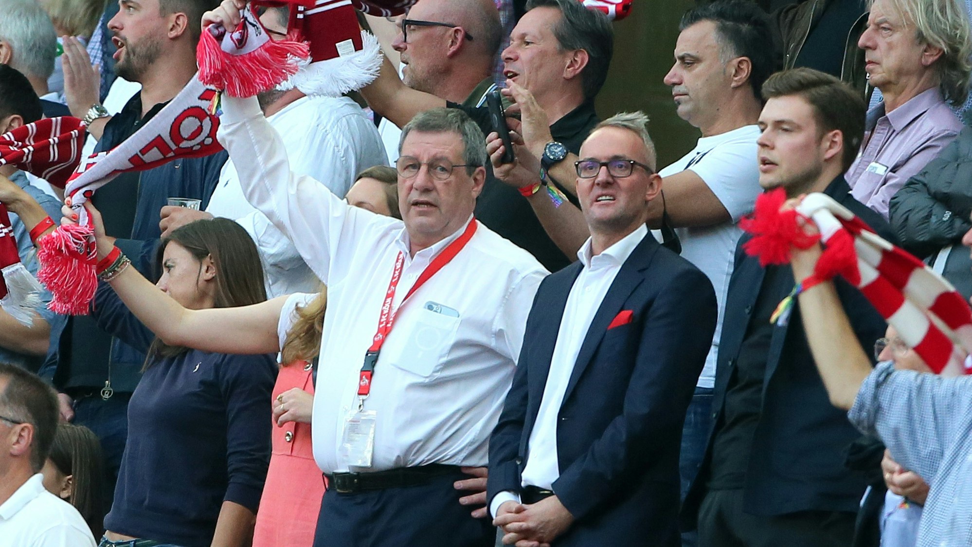 Werner Wolf und Alexander Wehrle stehen beim Bundesliga-Spiel 1. FC Köln gegen RB Leipzig auf der Tribüne.