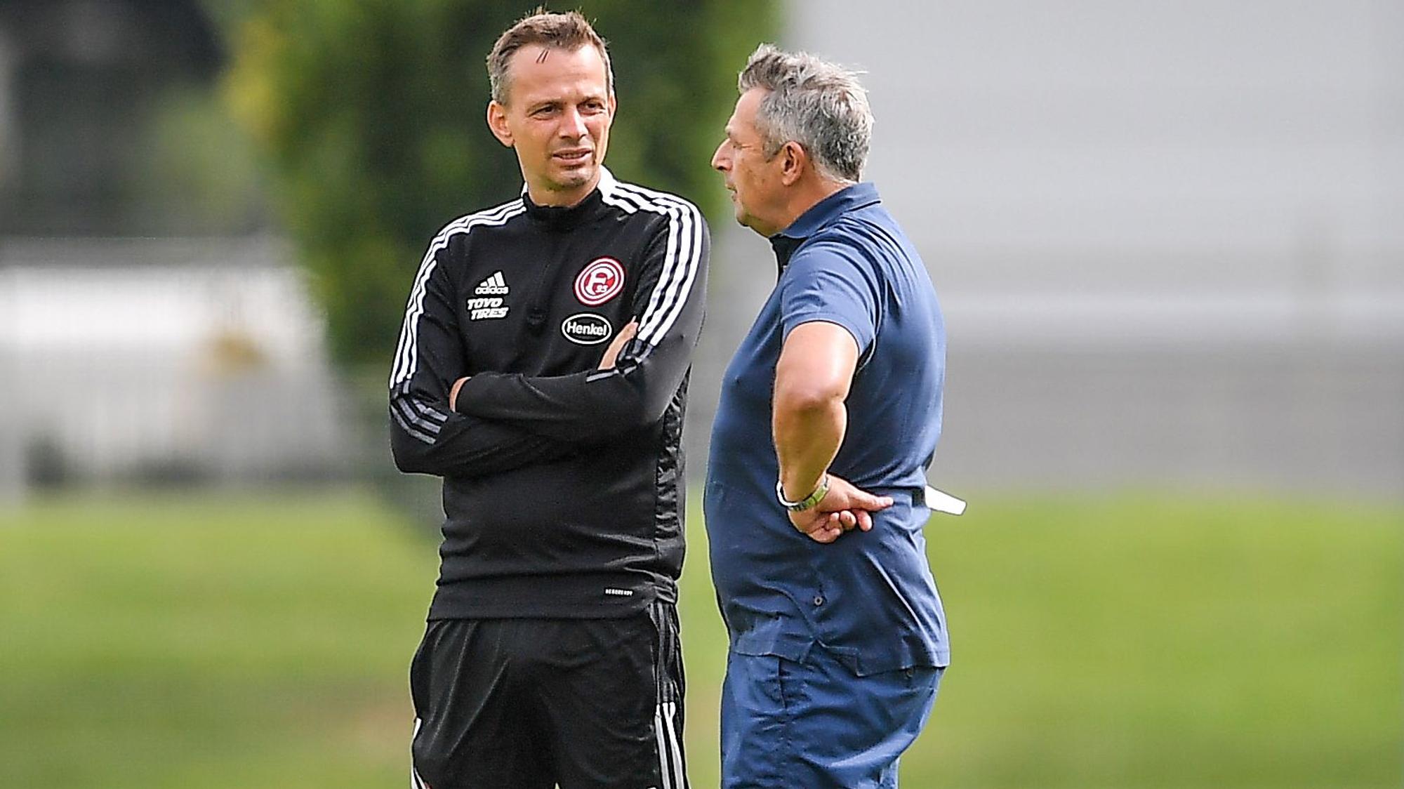 Fortuna Düsseldorfs Vorstand Klaus Allofs (r.) und Trainer Christian Preußer im Gespräch auf dem Trainingsplatz.