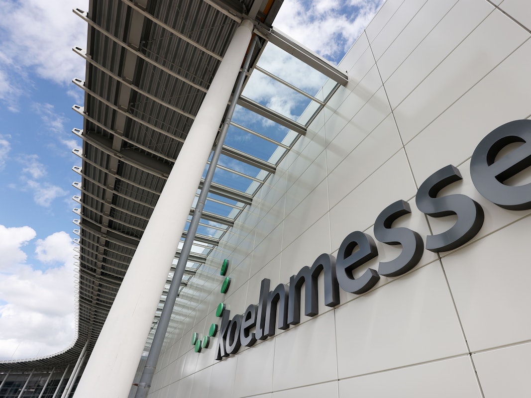 Der Schriftzug Kölnmesse hängt an einer Messehalle.