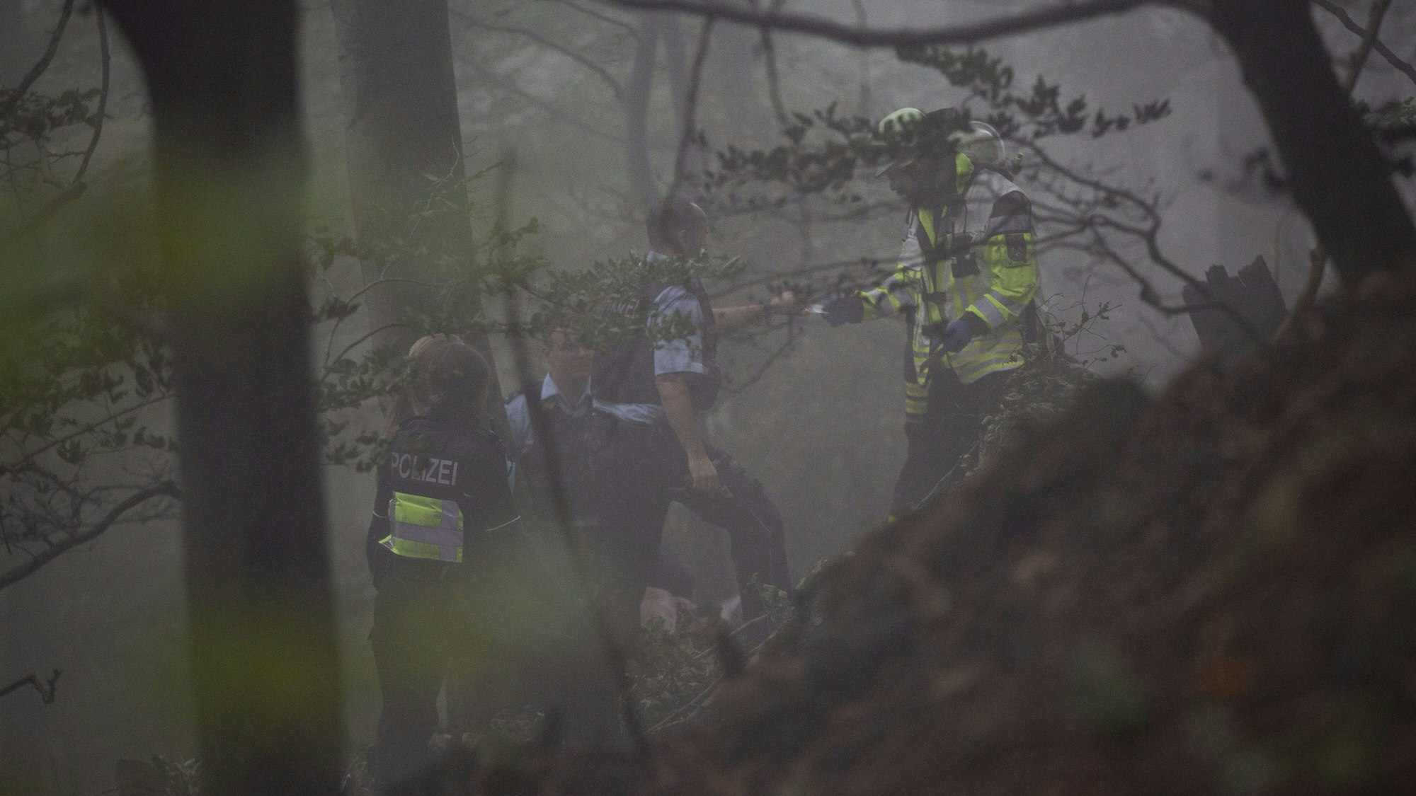 Einsatzkräfte stehen im Nebel im Wald im Siebengebirge.