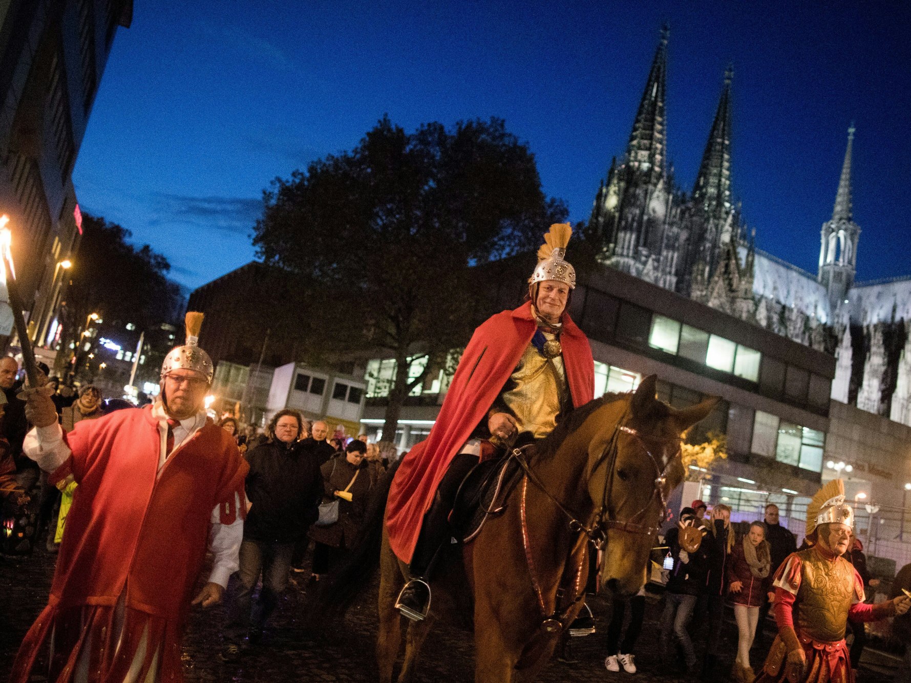 Ein Darsteller des Heiligen Martin reitet 2017 bei einem Zug am Kölner Dom vorbei.