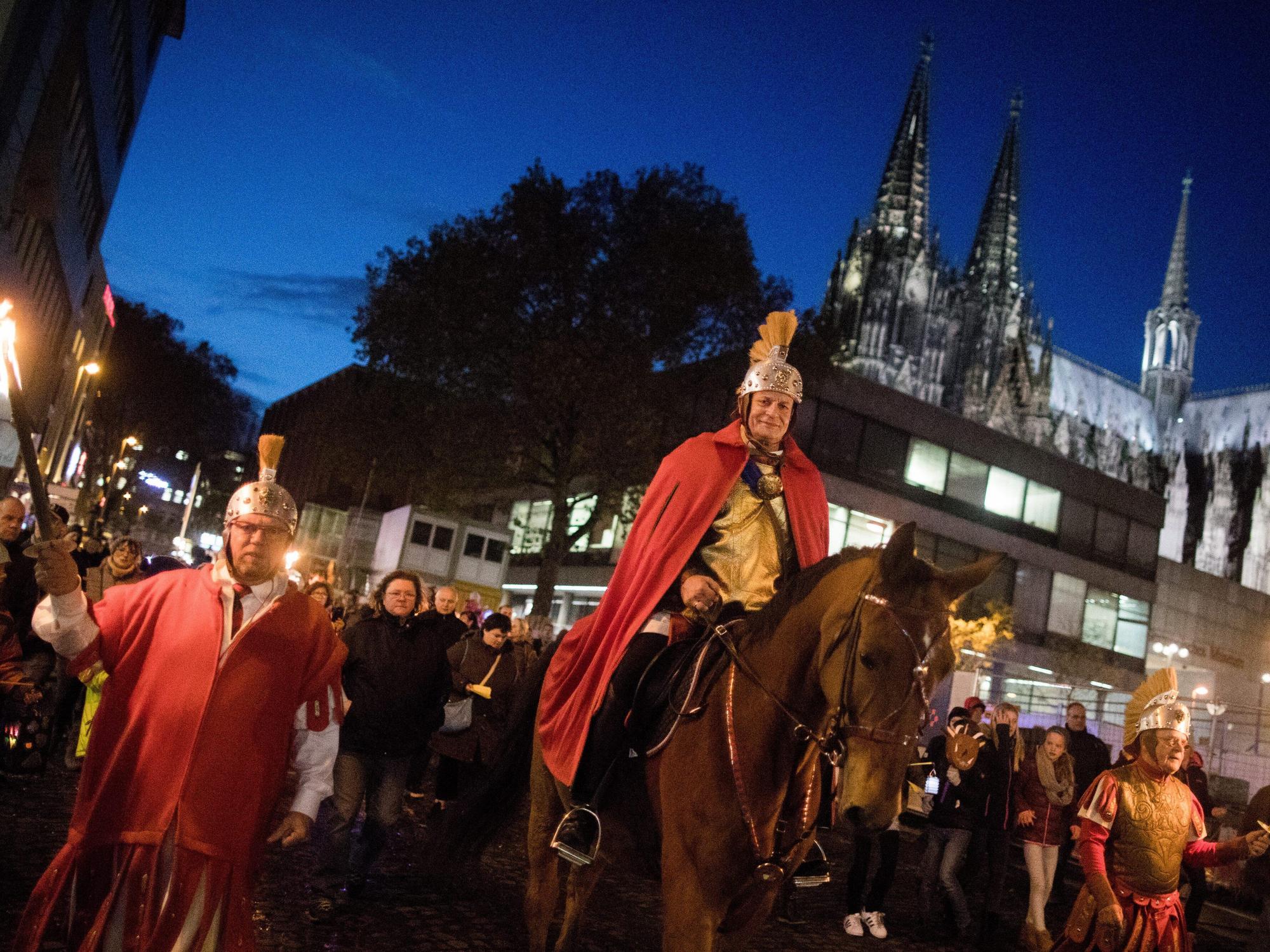 Ein Darsteller des Heiligen Martin reitet 2017 bei einem Zug am Kölner Dom vorbei.