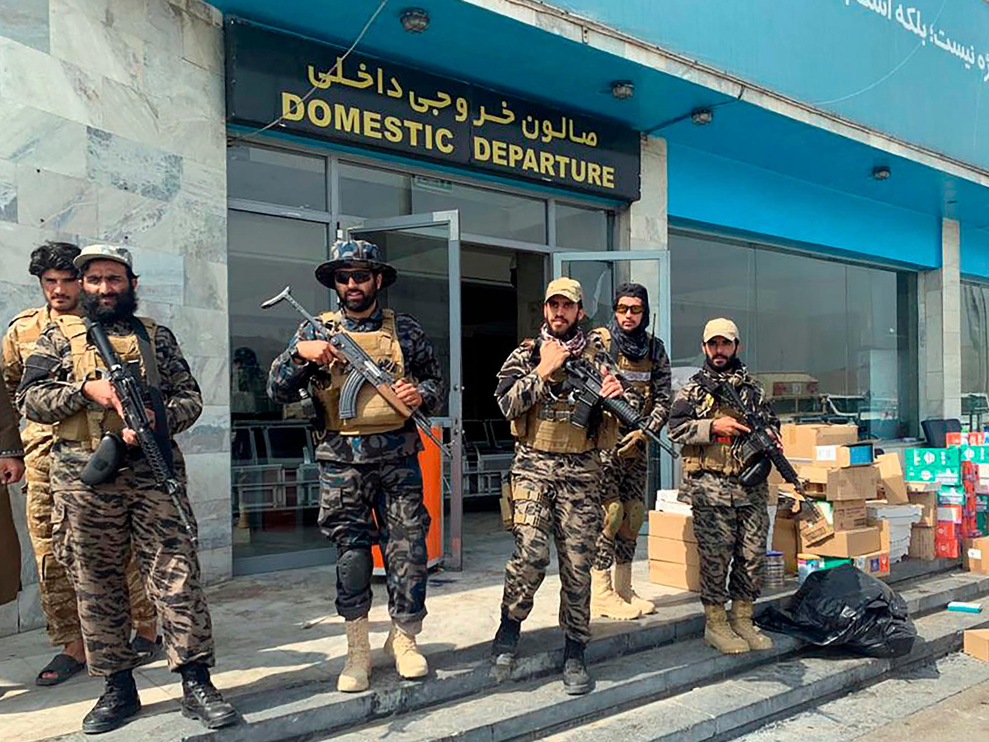 Taliban-Kämpfer stehen am 31.08.2021 vor dem Hamid Karzai International Airport in Kabul, Afghanistan.