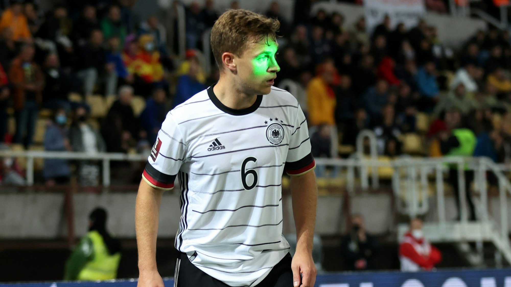 Ein Laserstrahl ist bei Deutschlands Spiel in der WM-Quali in Nordmazedonien genau auf das Gesicht von Joshua Kimmich gerichtet.