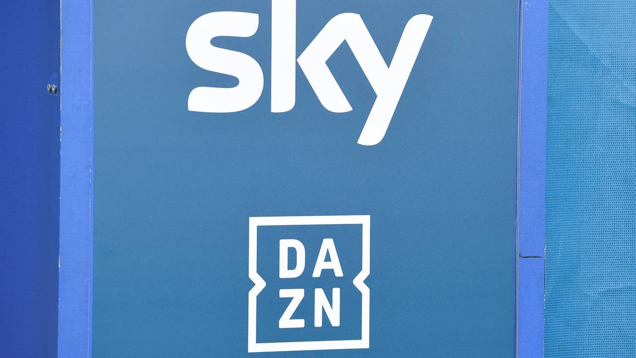 Die Logos der TV-Anbieter Sky und DAZN sind auf eine Tafel gedruckt.