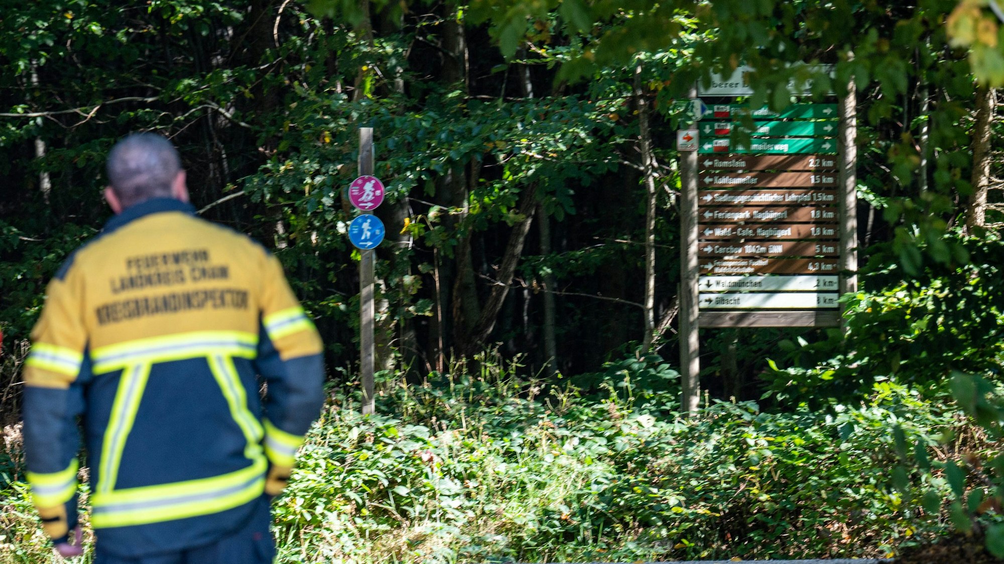 Bayern, Waldmünchen: Ein Feuerwehrmann steht an einem Wanderweg.