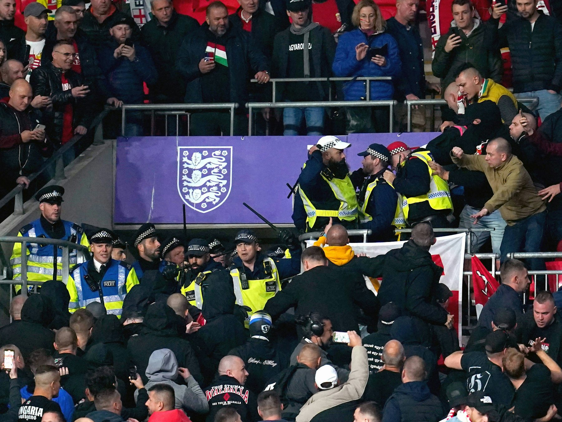 Ein Gruppe englischer Polizisten in Warnwesten stürmt in den Block der Ungarn. Die mitgereisten Ungarn schauen dem Treiben zu.