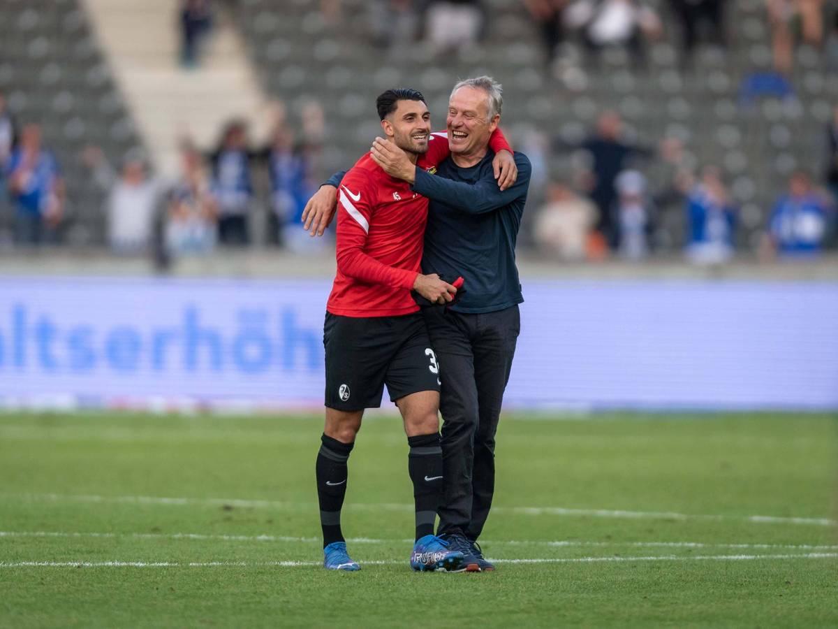 Christian Streich (r.) und Vincenzo Grifo (l.) laufen Arm und Arm über den Platz.