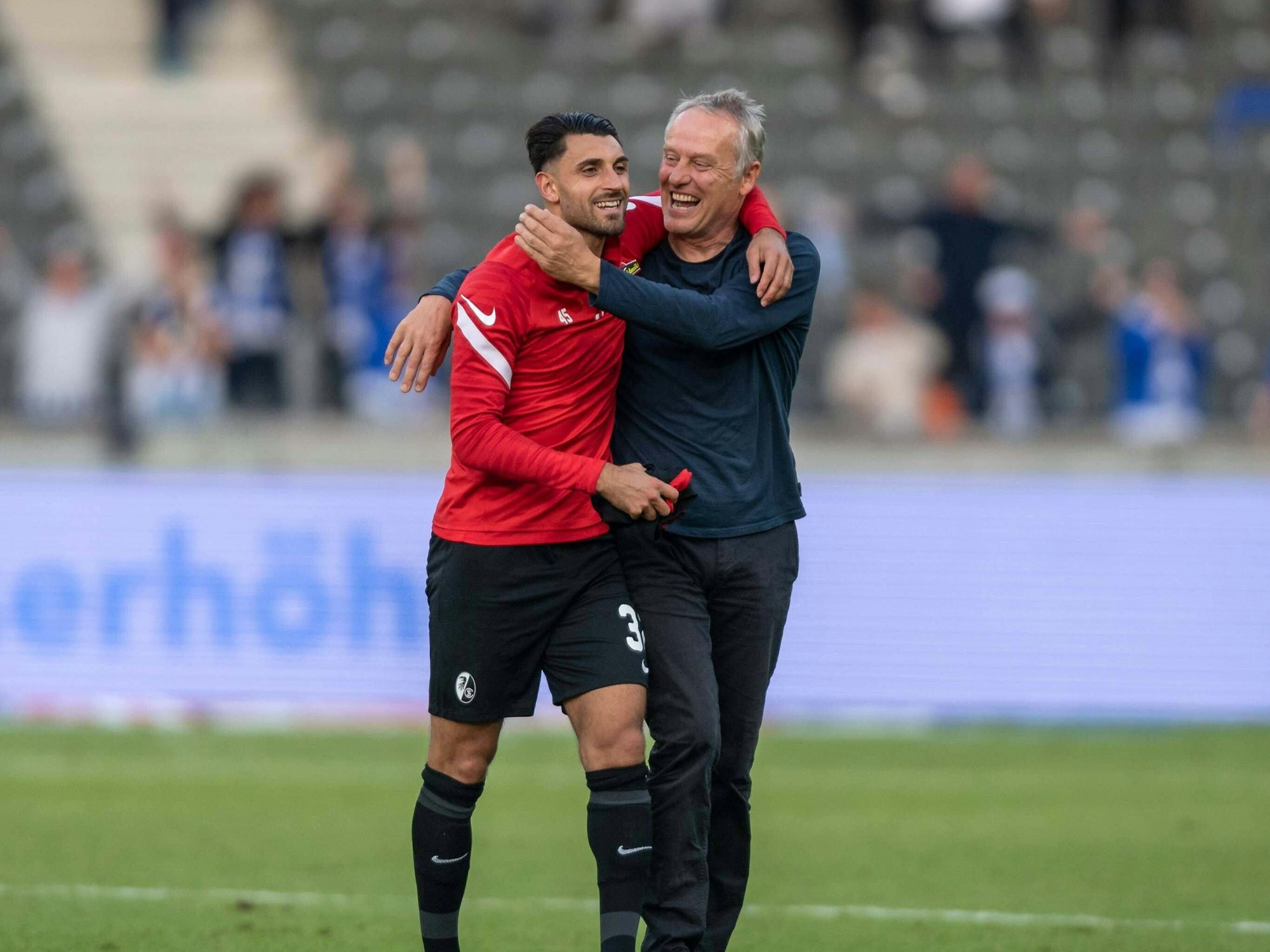 Christian Streich (r.) und Vincenzo Grifo (l.) laufen Arm und Arm über den Platz.