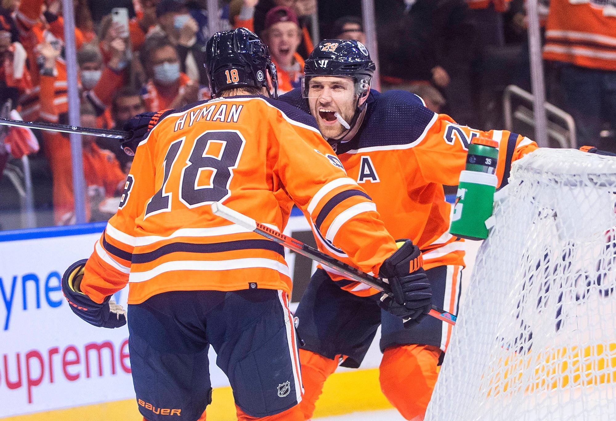 Zach Hyman und Leon Draisaitl laufen begeistert aufeinander zu.