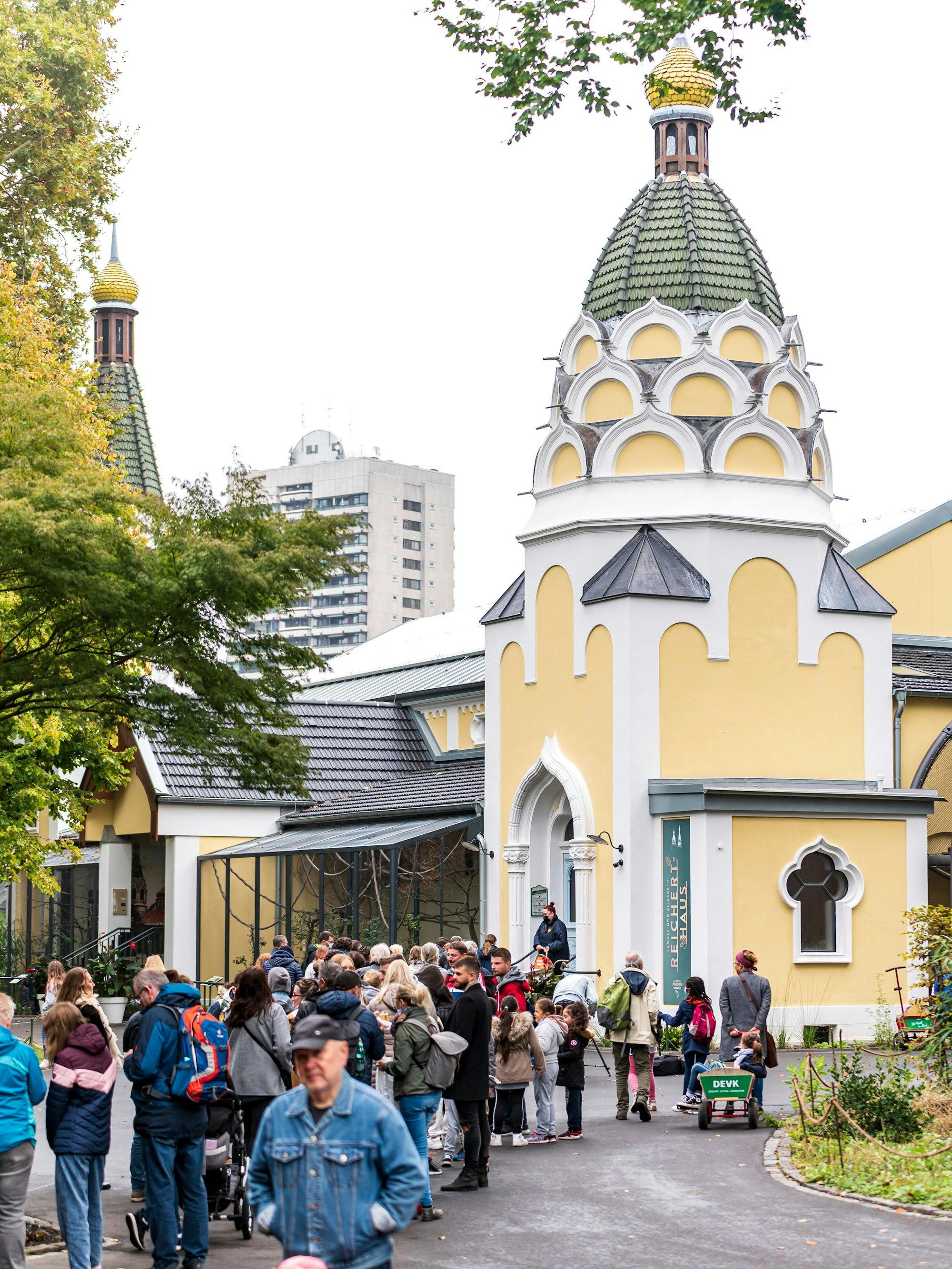 Menschen stehen Schlange vor einem Gebäude im Kölner Zoo.