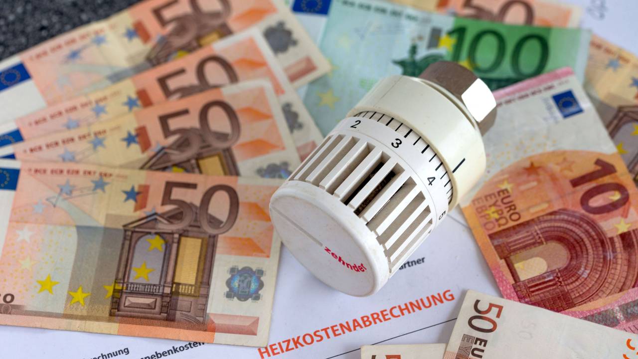 Ein Heizungsthermostat liegt aauf der Heizkostenabrechnung und Euro-Geldscheinen.