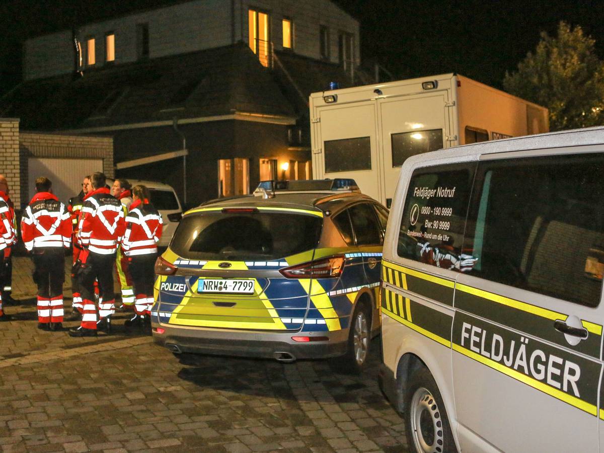 Zoll und Polizei stehen bei einer Razzia vor einem Gebäude.